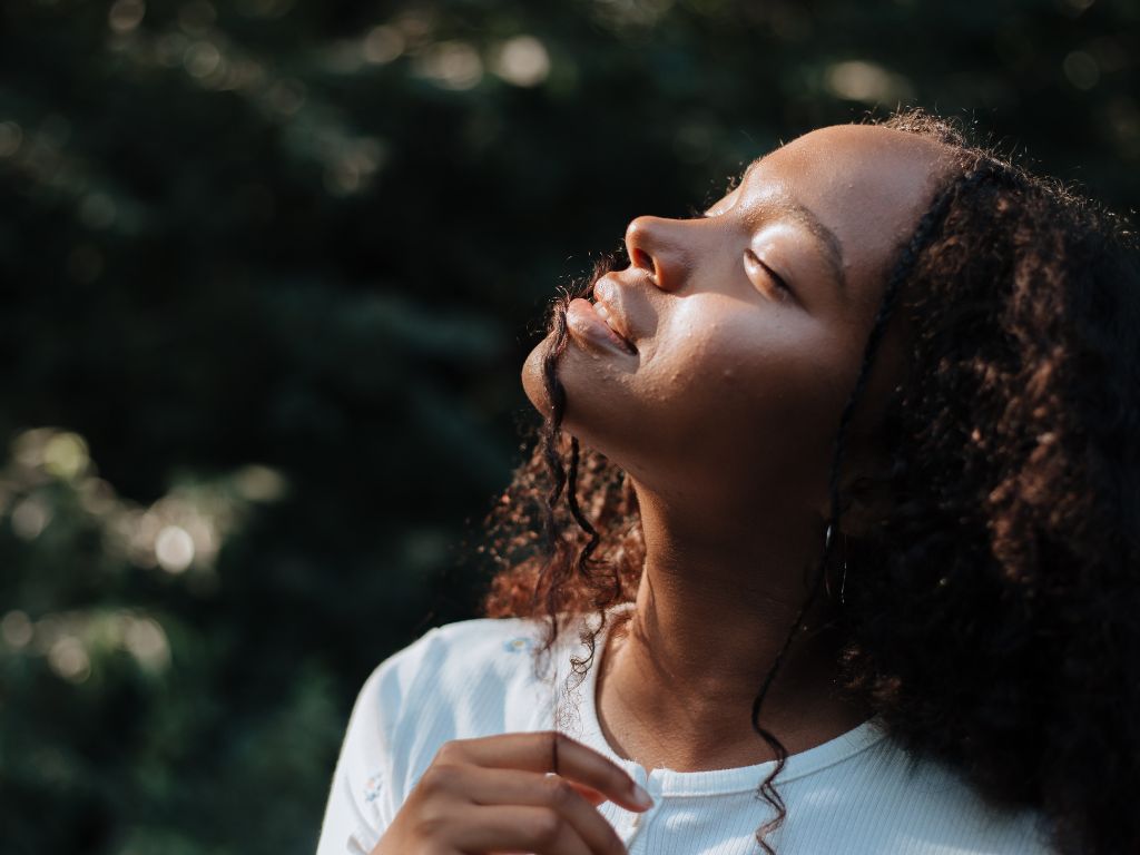 Jeune femme les yeux fermés dans un environnement naturel